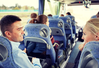 employees-talking-across-center-aisle-of-shuttle-bus