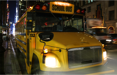 school-bus-parked-on-busy-city-street-at-night