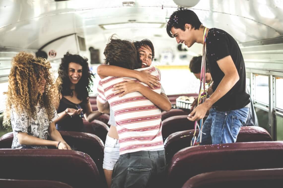 adult-friends-hugging-smiling-inside-bus