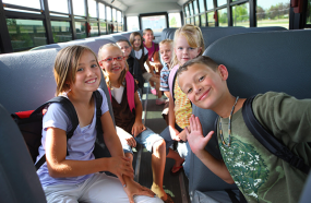 elementary-school-kids-smiling-interior-school_bus