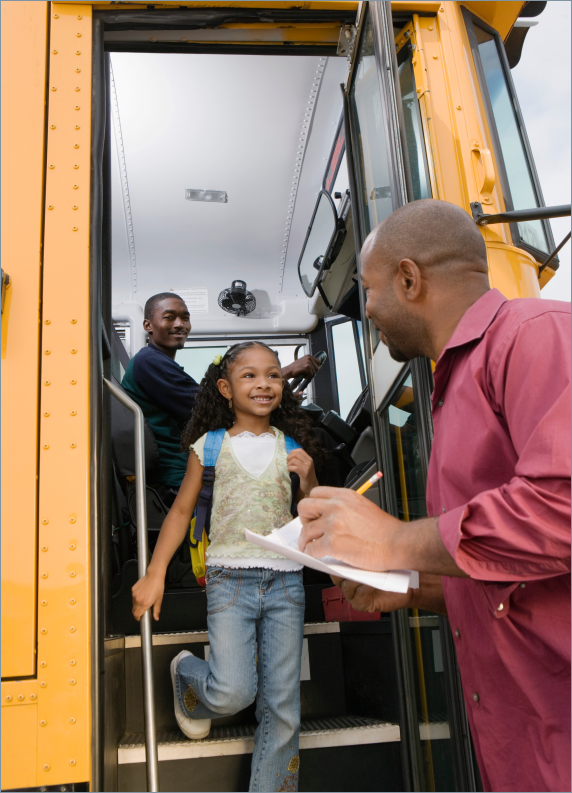 male-school-bus-driver-greeting-child-on-bus