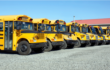row-of-school-buses-outdoors-parking-lot