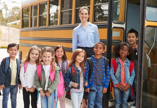 school-field-trip-teacher-kids-standing-by-bus
